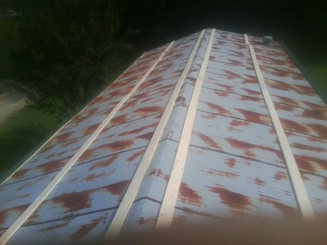 Rusted metal roof panels with new wood purlins before replacement — Storm Damage Roof Repair in Crozier by Roofing Brothers