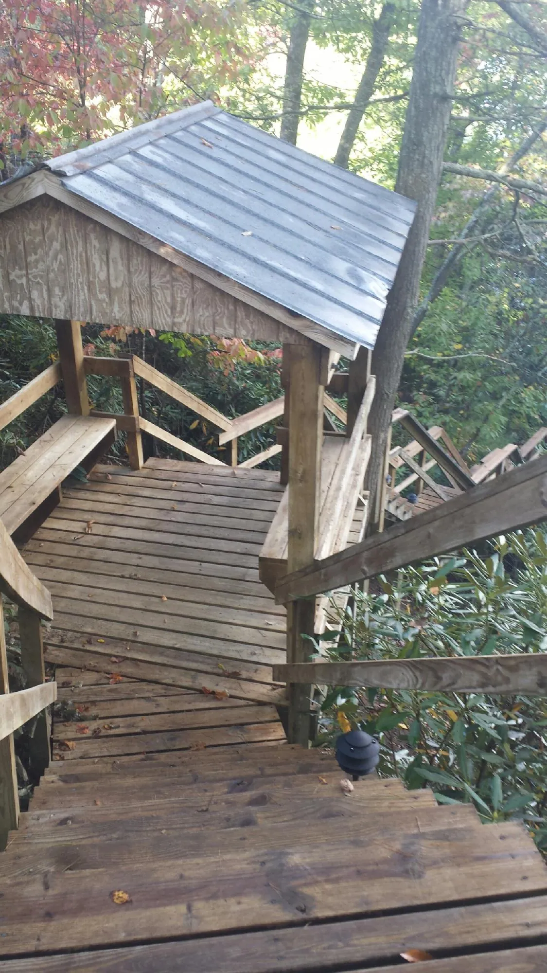 Metal roofed shelter over wooden steps on a wooded walkway — Skylight Repair & Installation work by our crew in Crozier