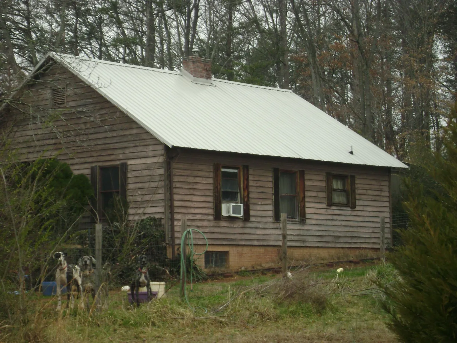 White metal roof on an old wood sided farmhouse, from a Metal Roof Installation job in Crozier